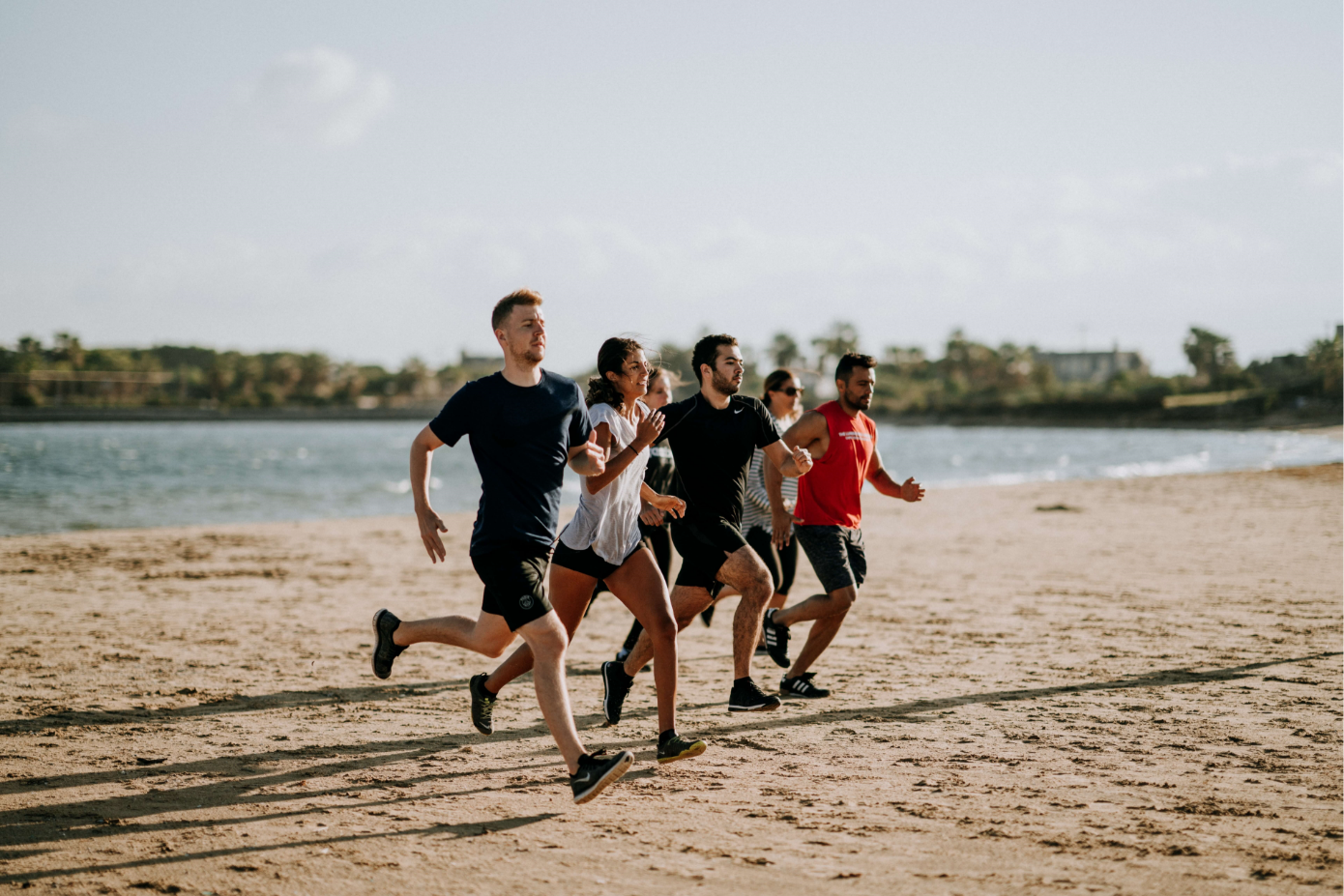 men and women running on beach